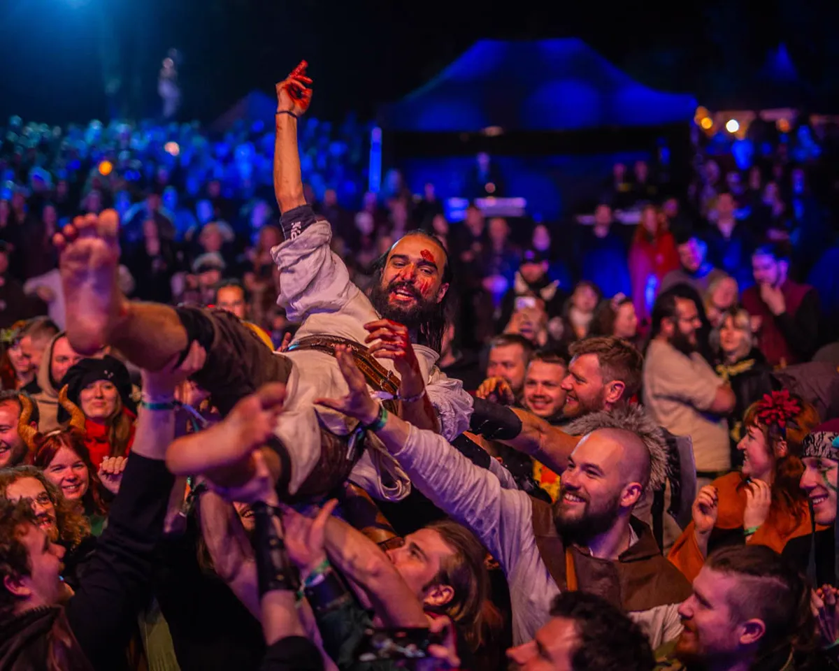 Fanoušci na festivalu Con Morhen nesou nad hlavami účastníka v kostýmu